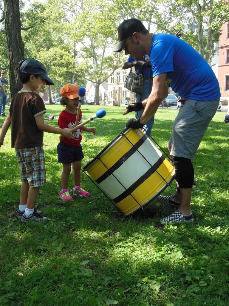 Children accompany a Timbeleza percussionist on the surdo, a type of Brazilian bass drum.