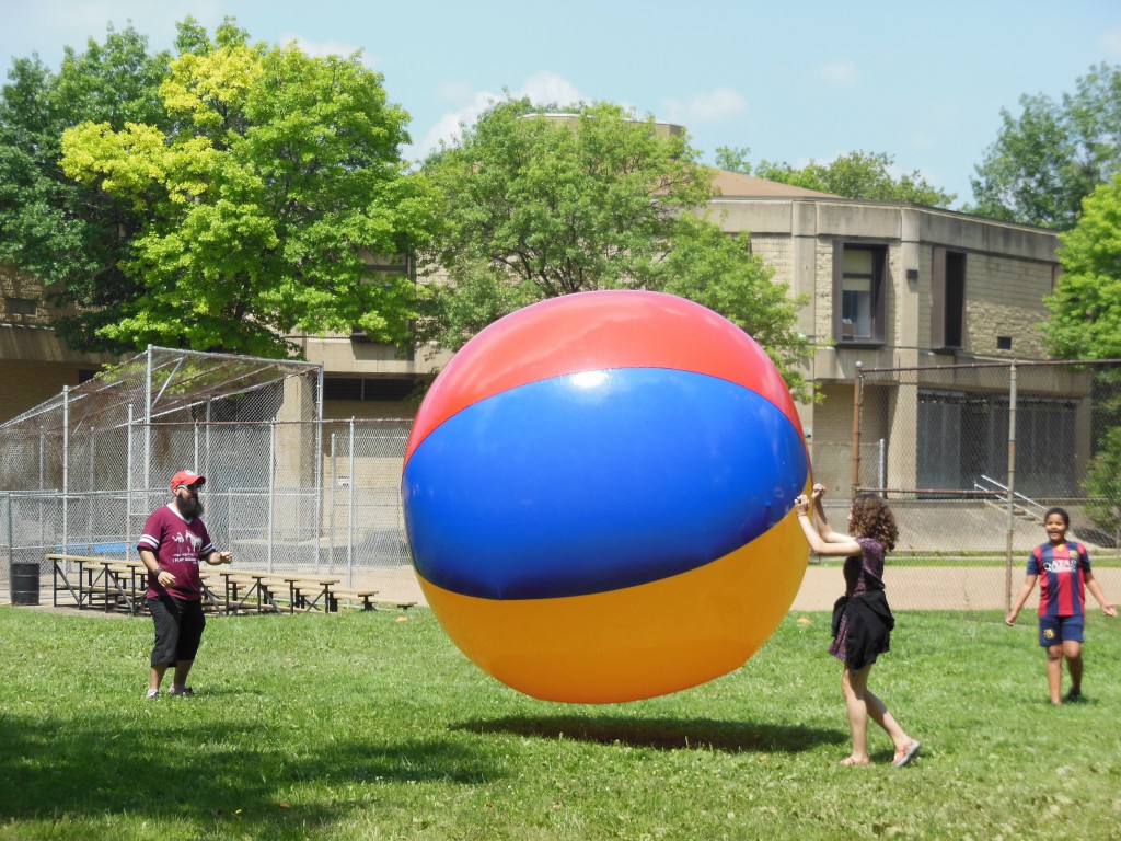 Attendees at Allegheny Commons East bounce the giant beach ball, courtesy of The City of Play, an organization which promotes playful ways for Pittsburghers to engage in their city.