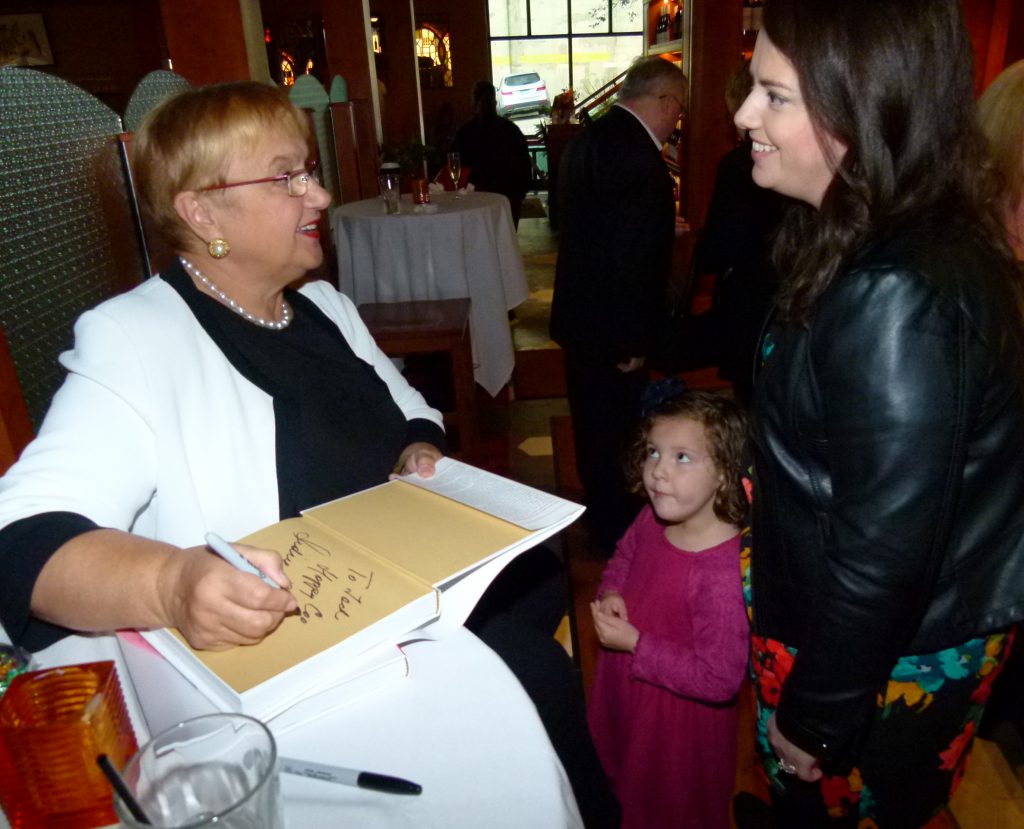 Grace from Cleveland looks in awe at Lidia while Lidia signs a children's book for her and talks with her mom Natalie Kupinski.