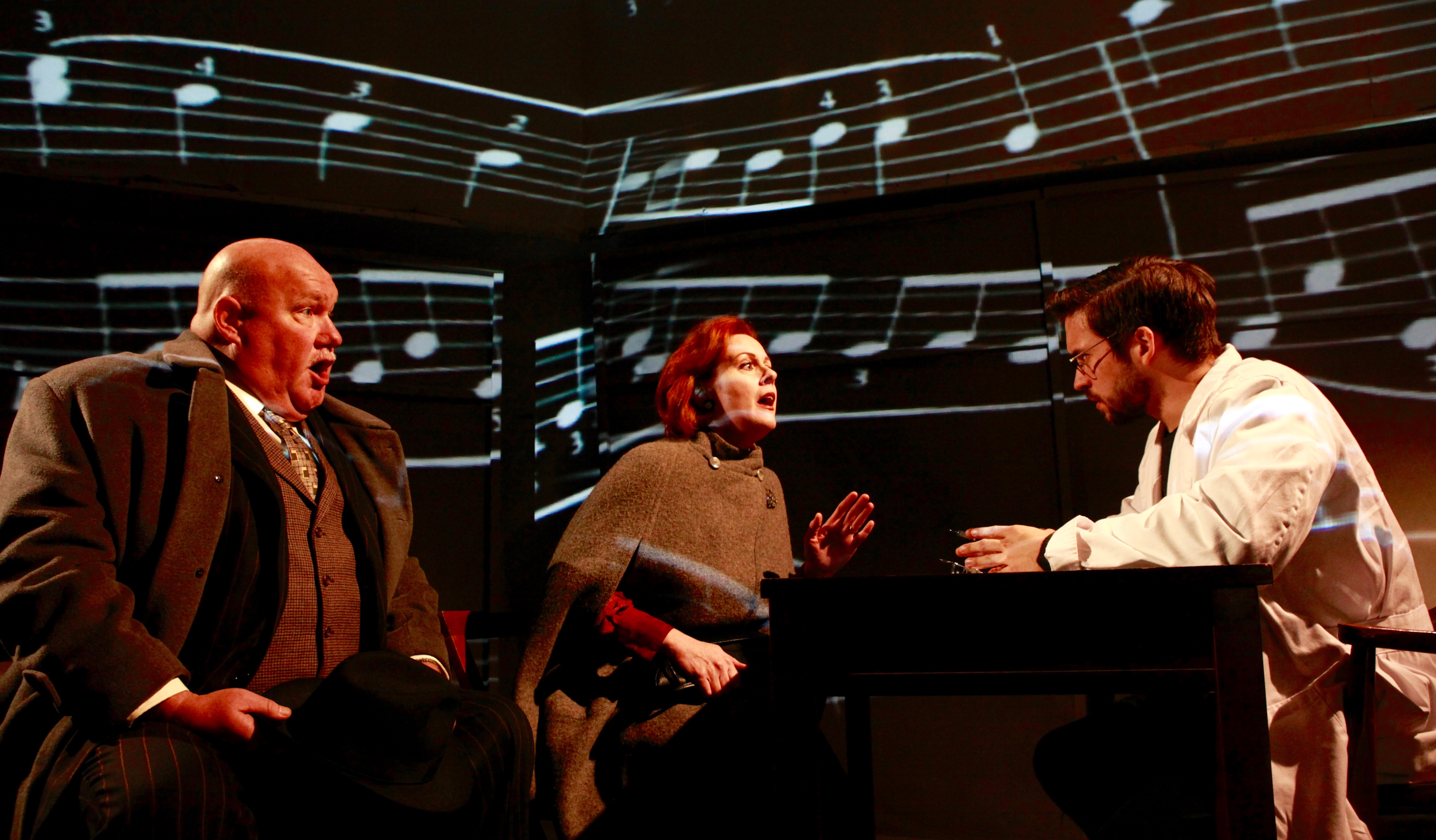 That's no Christmas carol; it's "The Man Who Mistook His Wife For A Hat." Quantum Theatre's production of this modern opera features (L to R) bass Kevin Glavin, soprano Katy Williams, and tenor Ian McEuen.