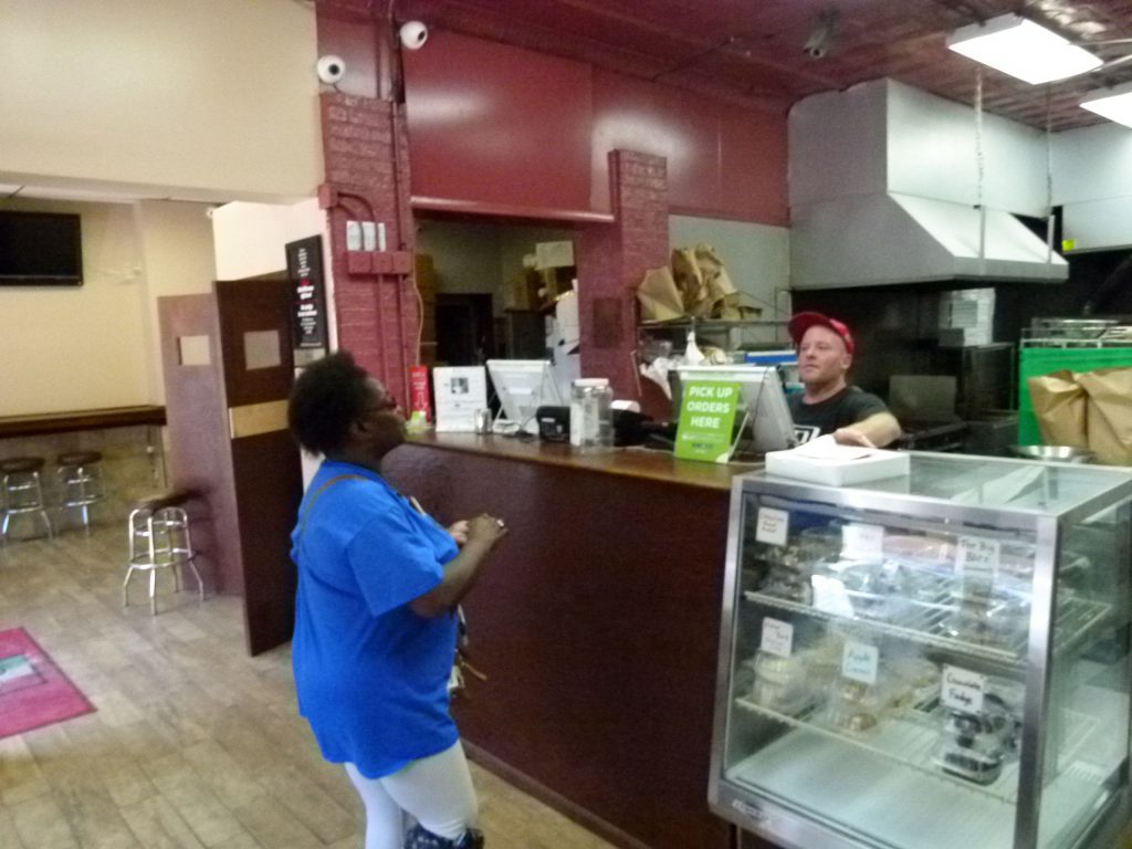 Keith Schrum rings up a take-out pizza order for a customer at Larry & Carol's.