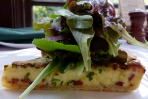 Green onion and bacon quiche topped with spring mix from The Frick's greenhouse.