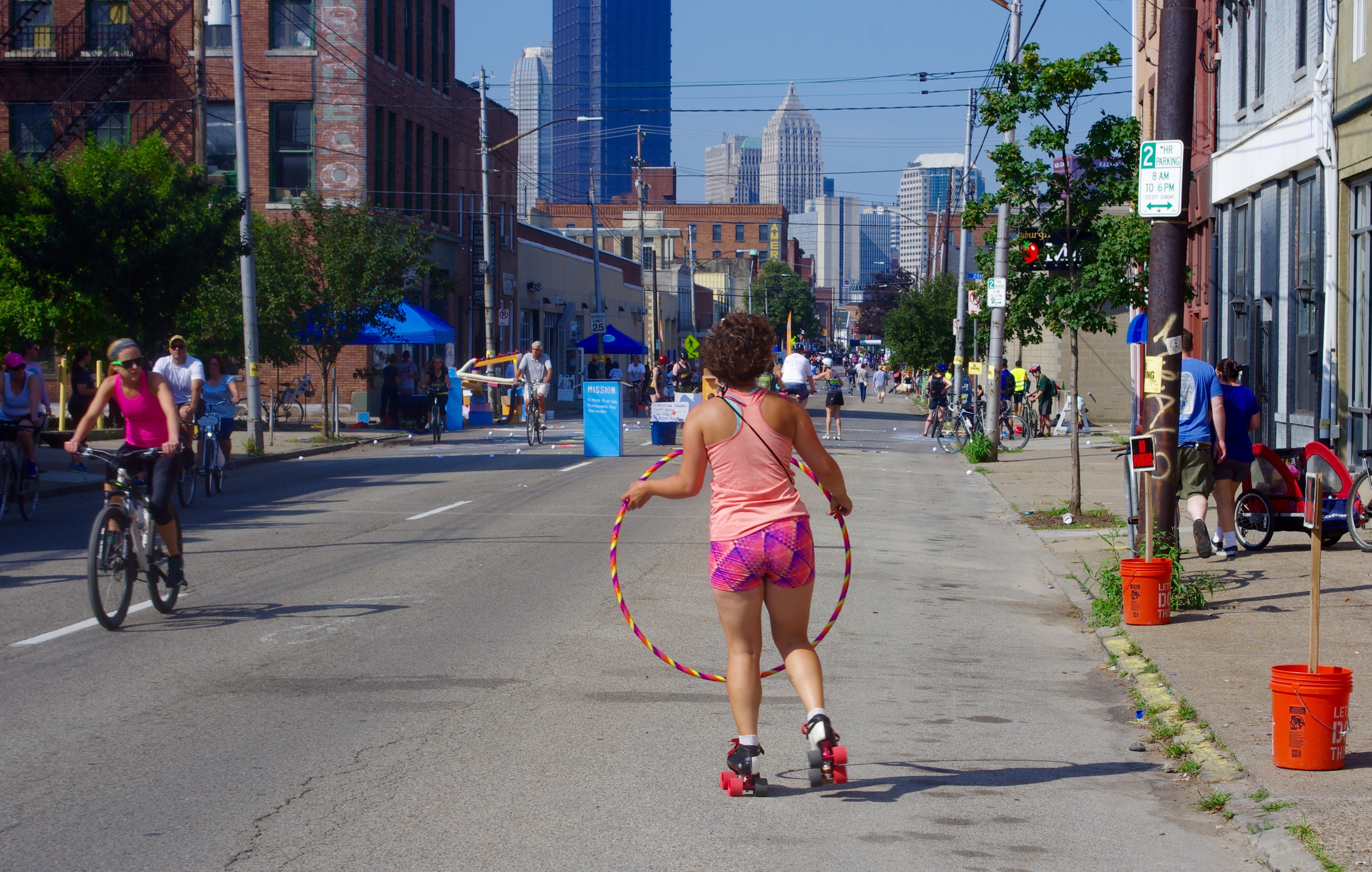Holly Miller hula hoops while roller skating towards downtown.