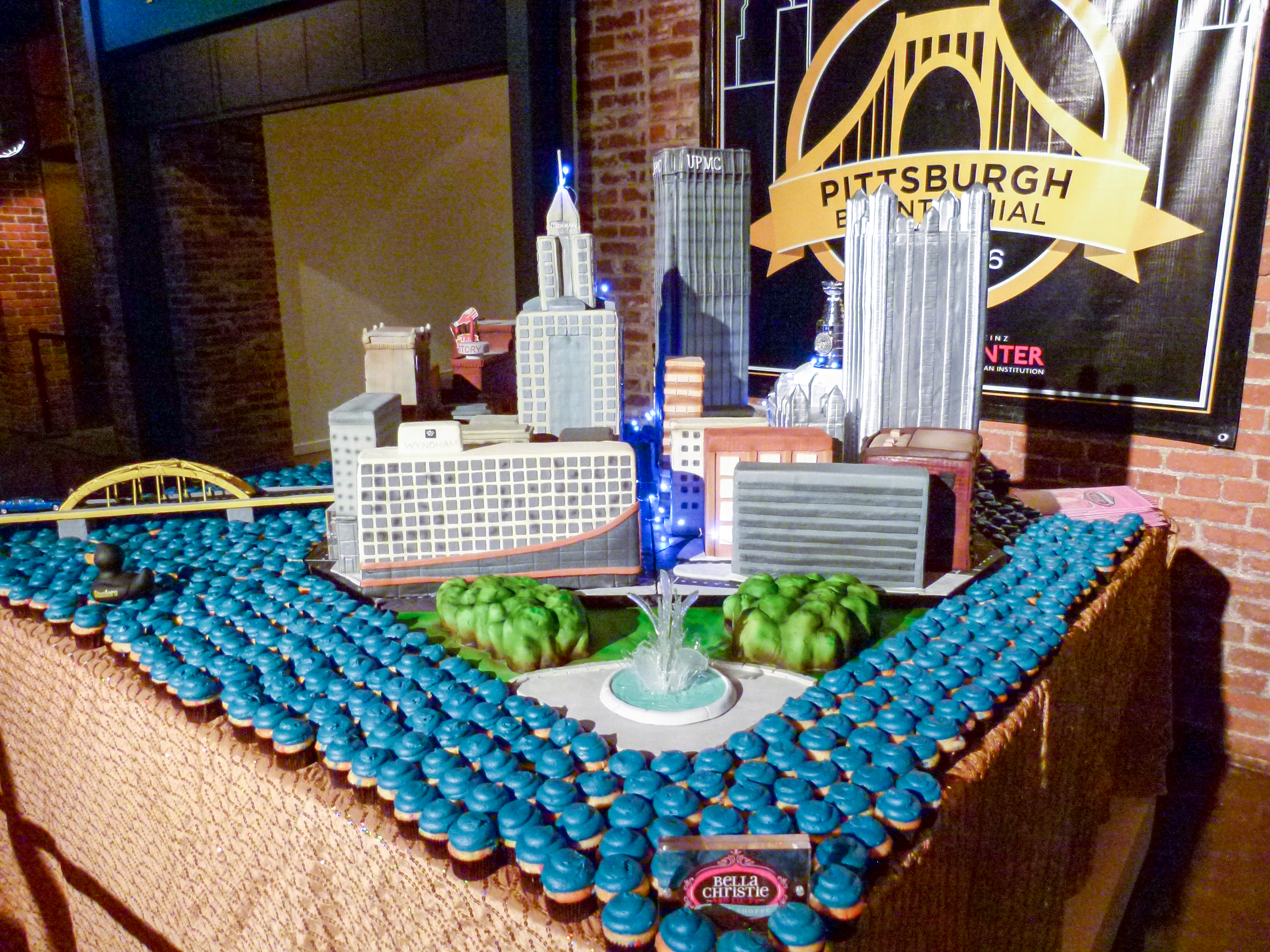 A beautiful cake of Pittsburgh. Notice the crystalline sugar "water" emerging from the fountain and the Heinz History Center with it's Heinz Ketchup bottle in the background.