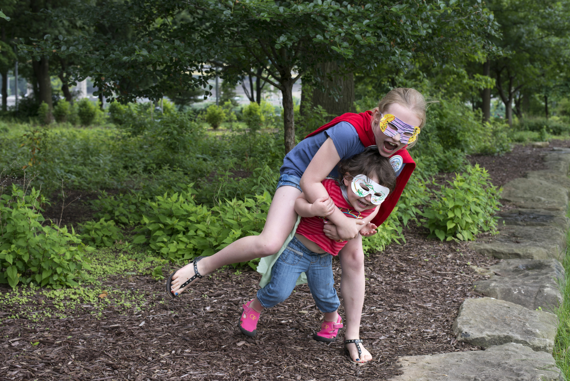Superheroes Amanda Palmer, 9, and younger sister Jayda , 2, of Economy play at Point State Park after making masks and capes at Giant Eagle’s Creativity Zone.