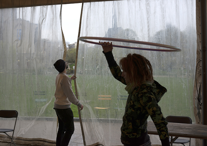 Alex Sadlo, of the Pittsburgh Flow Collective, dances while volunteers adjust a rain curtain at the Schenley Plaza pavilion.