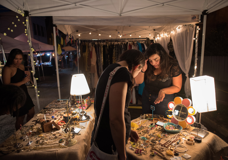 Marigrace Ambrosia (R) shares the story behind her collection of vintage jewelry for sale in a popup booth at the Garfield Night Market. Ambrosia and her colleague Sara Ponsoll are founders of Kitschtopia, an online vintage fashion store.