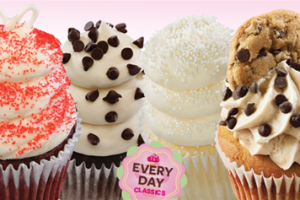 A delicious assortment of Gigi's cupcakes with swirled icing piled high and decorated with tasty chips and sprinkles.