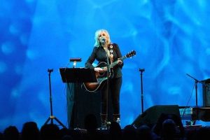 Lucinda Williams performing outdoors at Lincoln Center in New York City in 2016. (photo: Didier Moïse and Wikipedia)