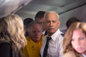 Sully makes sure everyone evacuates the plane quickly and safely. photo: Warner Bros. Entertainment.|Captain "Sully" Sullenberger (Tom Hanks) keeps a steady eye on the situation while first officer Jeff Skiles (Aaron Eckhart) checks the emergency handbook.
