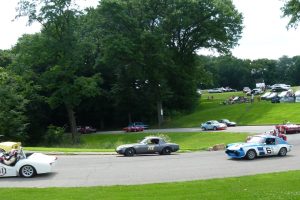 The vintage race cars come screaming along a curve on the road through Schenley Park's golf course.