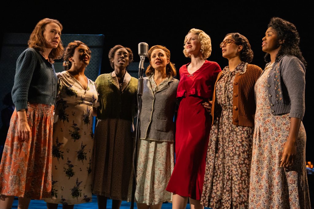 Delivering Dylan in subtle harmony, guests at the Duluth boardinghouse come together. Cast members include (l. to r.) Jennifer Blood, Carla Woods, Ashley D. Brooks, Kelly McCormick, Jill Van Velzer, Chiara Trentalange, and Sharaé Moultrie.