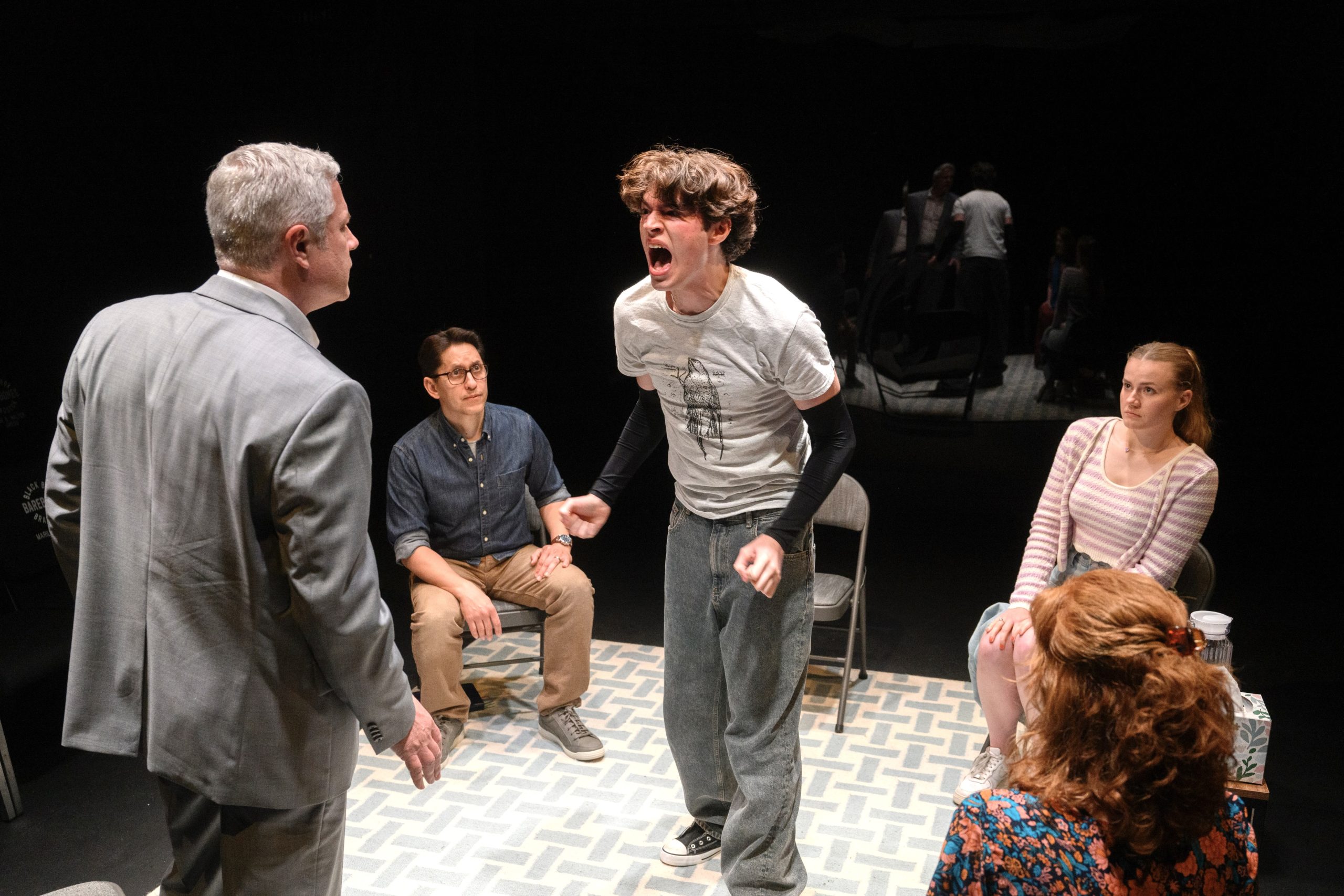 Prodigal son lashes out prodigiously: Sam (Greyson Taylor) has had it with Dad (Darren Eliker, L). The hands-off referee is therapist Daniel (Juan Rivera Lebron); the spectators are Sam's sister (Alexandra Casey) and mother (Daina Michelle Griffith, showing red hair).