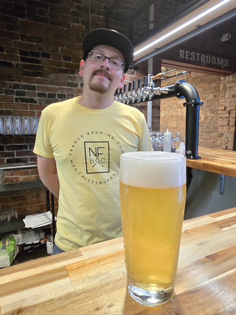 Nathan Johnston, New France's head bartender with a just pulled draft of Joie De Vivre, a 5.5% Belgian white with coriander and orange peel. (Photo: Rick Handler)