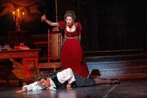 Tosca (Martínez) turns the tables on Baron Scarpia (Albertson) who must beg for his own miserable life.