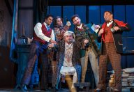 From Pittsburgh’s Opera’s 2019 production, the merry artists of La Boheme ply their landlord Benoit with drink in hopes he forgets to collect the rent. (Photo by David Bachman Photography.)