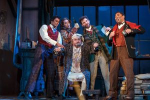 From Pittsburgh’s Opera’s 2019 production, the merry artists of La Boheme ply their landlord Benoit with drink in hopes he forgets to collect the rent. (Photo by David Bachman Photography.)