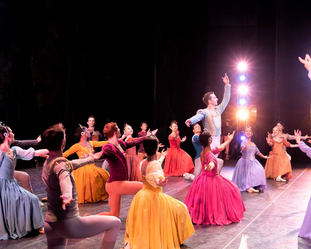 The court in colorful costumes dances with Prince Siegfried.