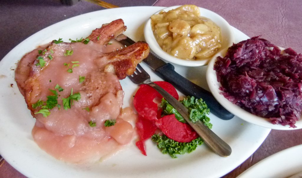 Roast loin of pork Stubenkuchen style with German potato salad and sweet and sour red cabbage.