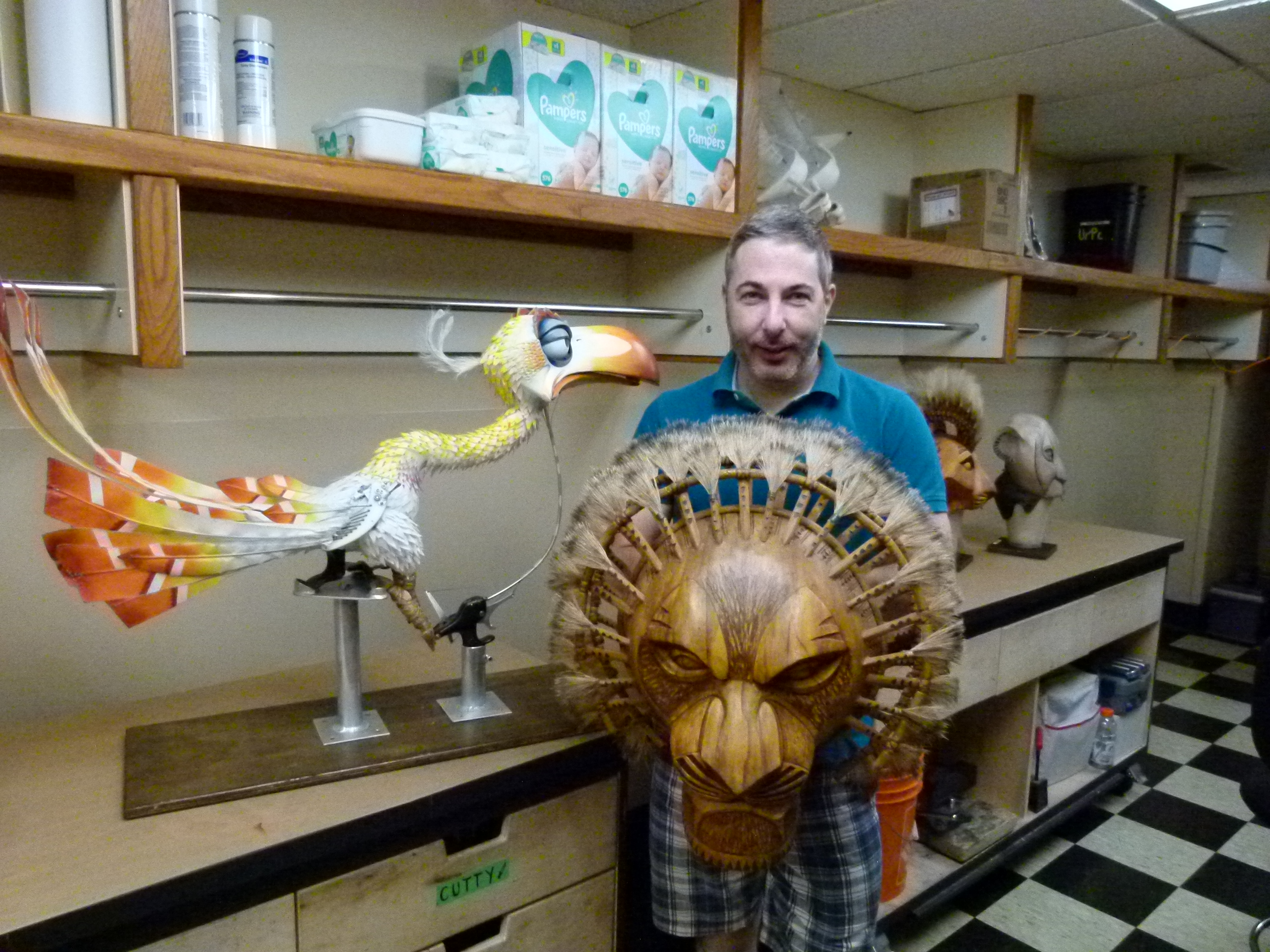 Puppet master Michael Reilly with his favorite mask, Mufasa, with the Zasu puppet looking on.