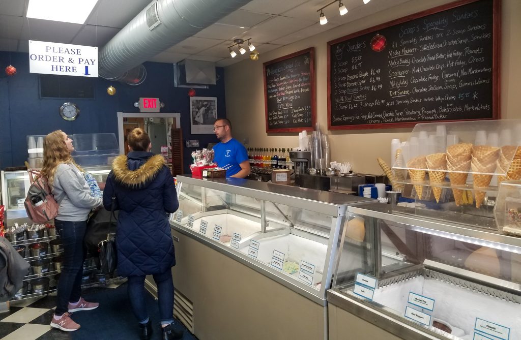 Scoops owner Mike Collins gets the ice cream order from two customers.