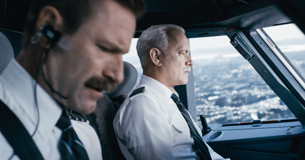 Captain "Sully" Sullenberger (Tom Hanks) keeps a steady eye on the situation while first officer Jeff Skiles (Aaron Eckhart) checks the emergency handbook.