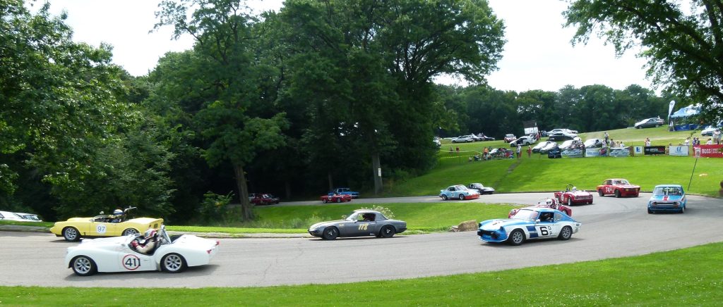 The vintage race cars come screaming along a curve on the road through Schenley Park's golf course.