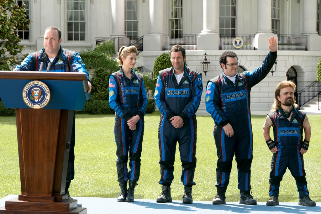 President Cooper (Kevin James) addresses the press on the White House lawn as Violet (Michelle Monaghan), Brenner (Adam Sandler), Ludlow (Josh Gad) and Eddie (Peter Dinklage) look on
